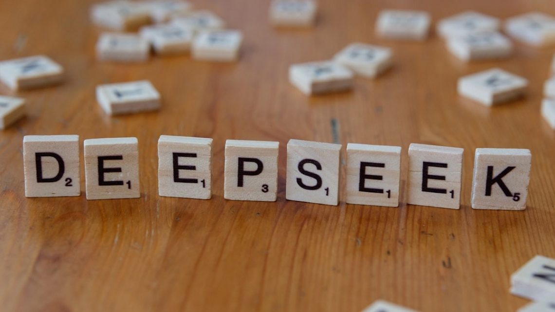 A wooden table topped with scrabble tiles spelling the word depeseek